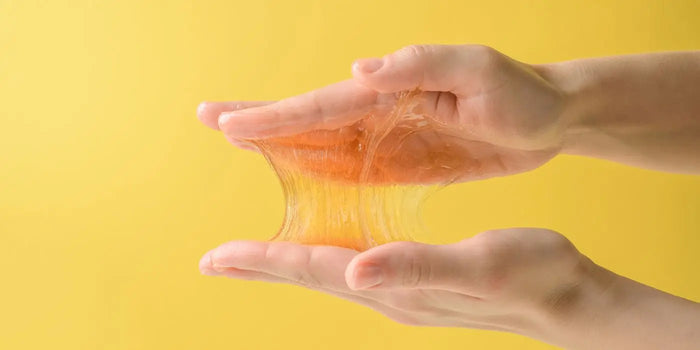 Mains qui testent l'adhérence des matériaux utilisés pour confectionner un soutien-gorge adhésif.