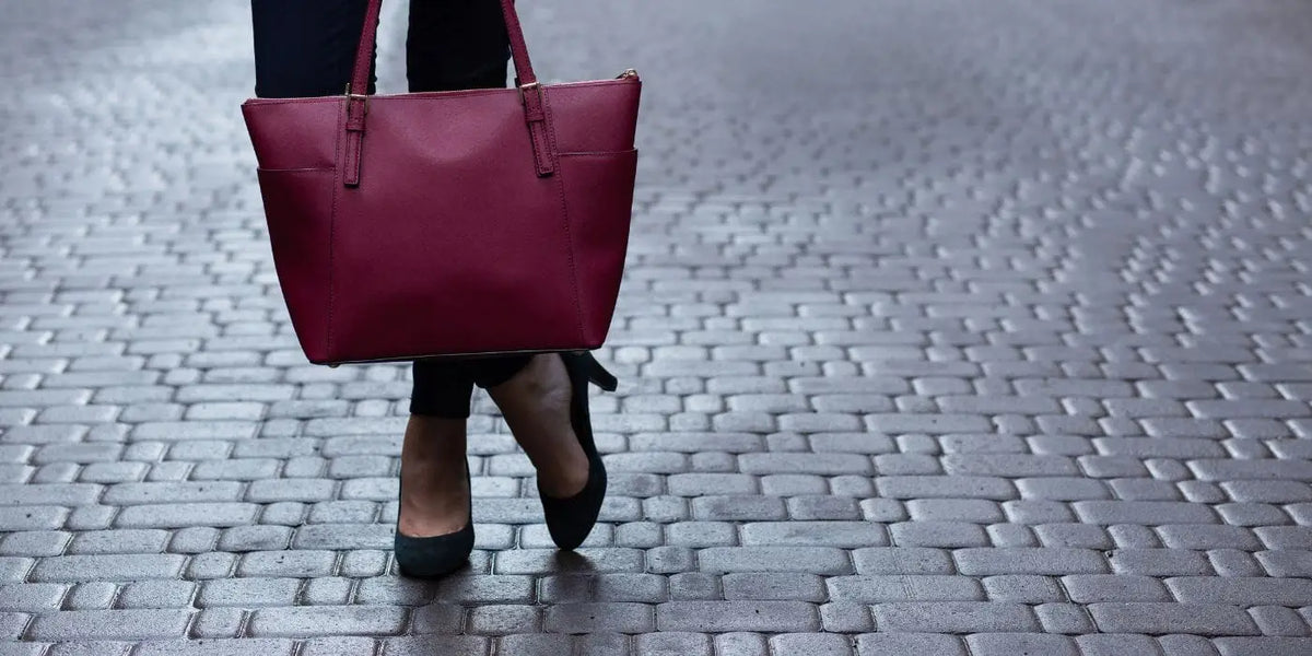 Sac à main élégant tenu par une femme portant des talons.