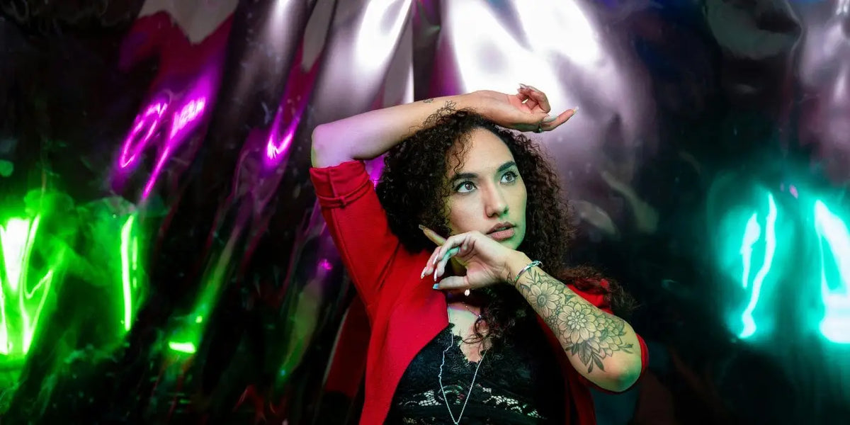 Femme portant un body en dentelle sexy et un blazer rouge.