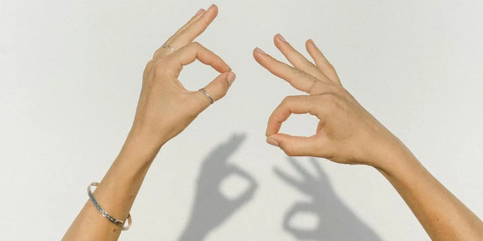 Femme portant des bagues et bracelets aux mains.