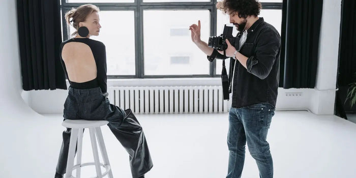 Femme portant un body dos nu noir, posant pour un photographe.