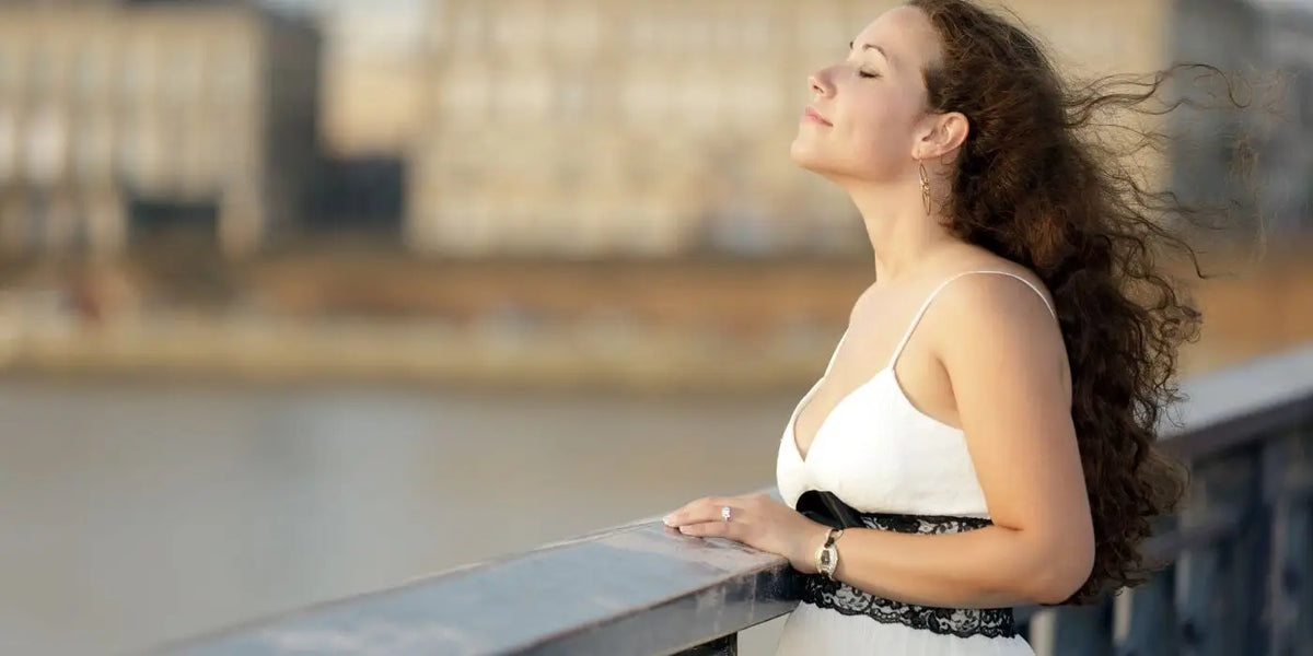 Femme portant une robe blanche sur un pont.