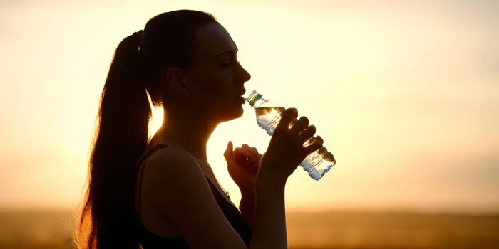 Silhouette d'une femme buvant de l'eau.