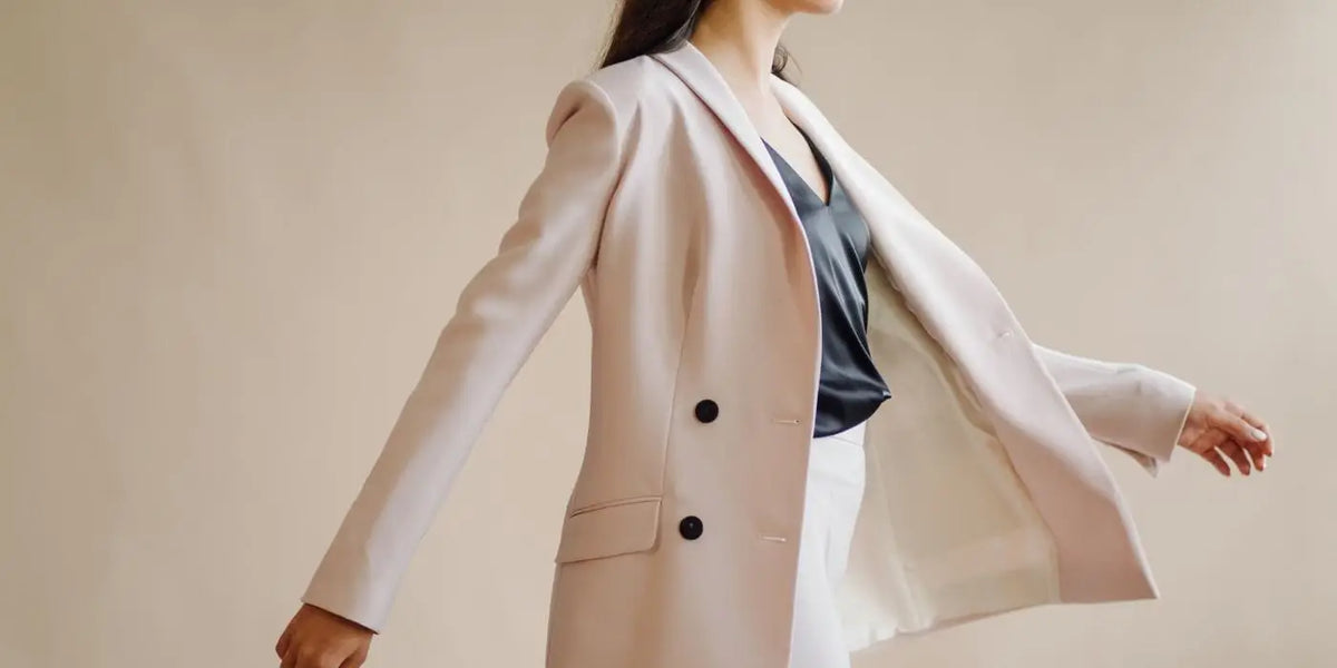 Femme portant un ensemble beige et un haut en satin noir.