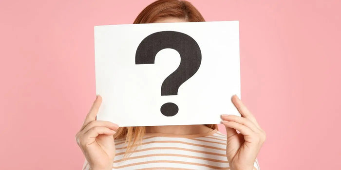 Femme portant une marinière et une feuille avec un point d'interrogation inscrit.