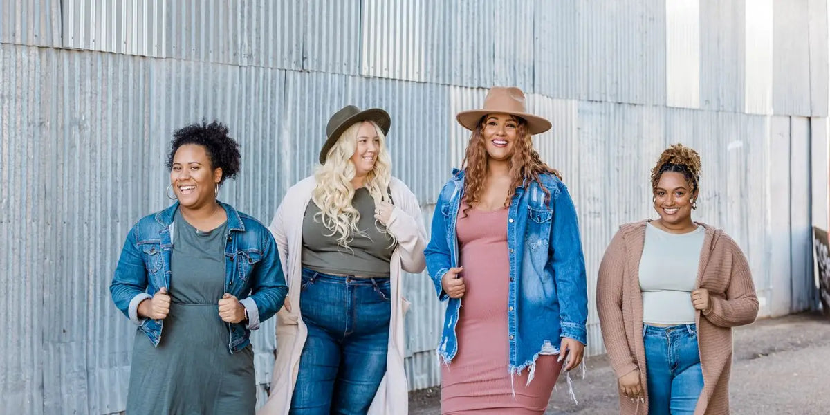 Quatre femmes portant des gilets ou vestes en jean pour cacher leurs bras avec une robe.