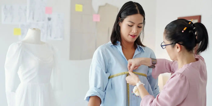 Couturière mesurant le tour de poitrine d'une femme.