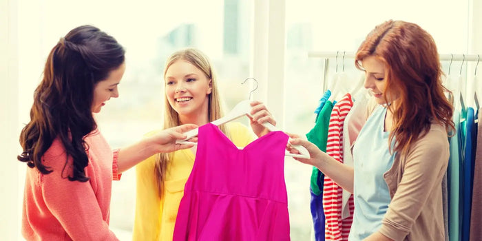 Trois femmes admirent une robe dans un magasin.