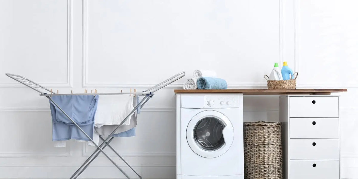 Machine à laver et linge qui sèche à côté.