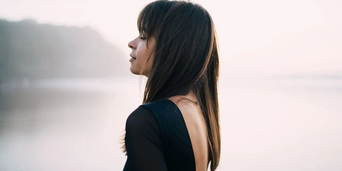 Femme portant une robe dos nu en V plongeant noire.