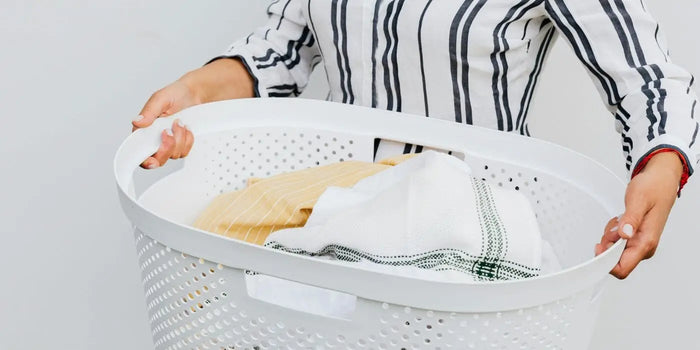 Femme portant un panier à linge.