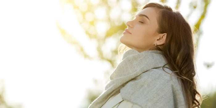 Femme portant une écharpe en laine mérinos, profitant du soleil d'hiver.