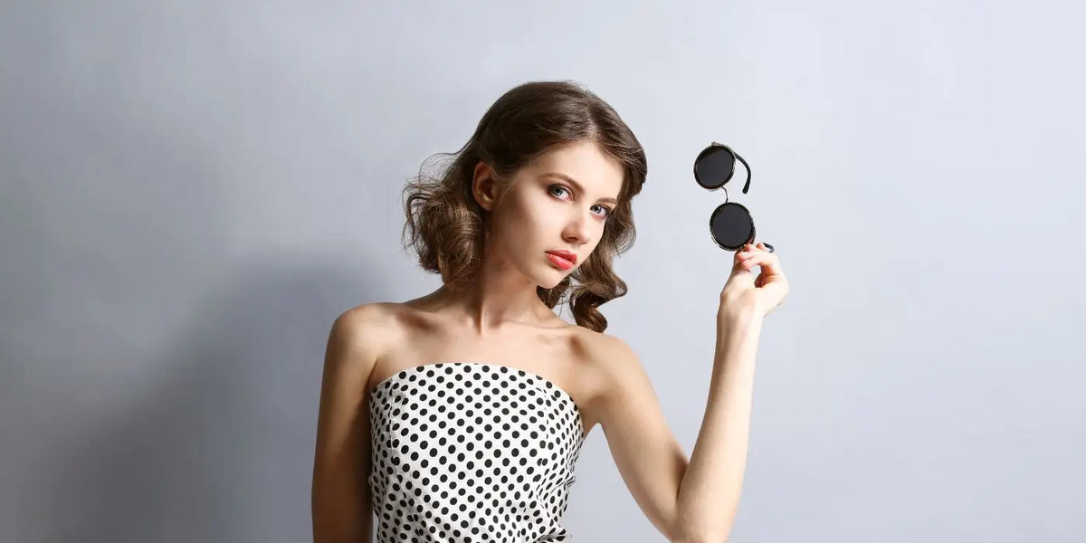 Femme portant un haut bustier blanc à pois noirs.