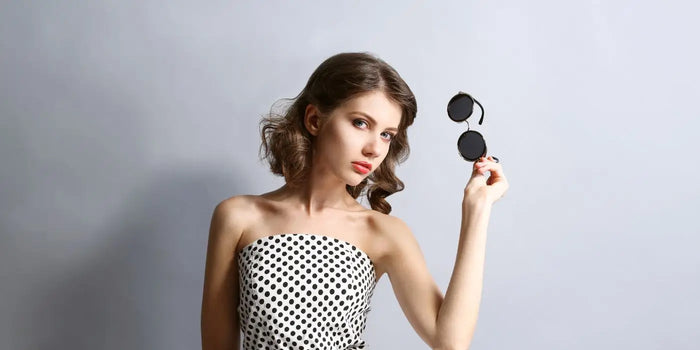 Femme portant un haut bustier blanc à pois noirs.