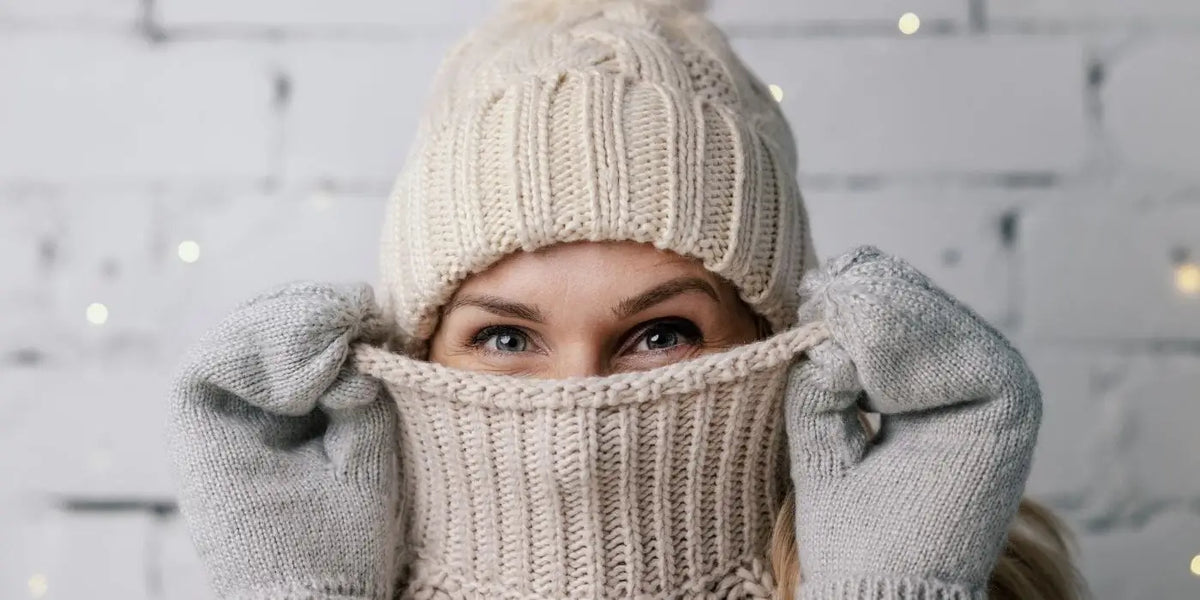 Femme portant un pull col roulé, un bonnet assorti et des gants.