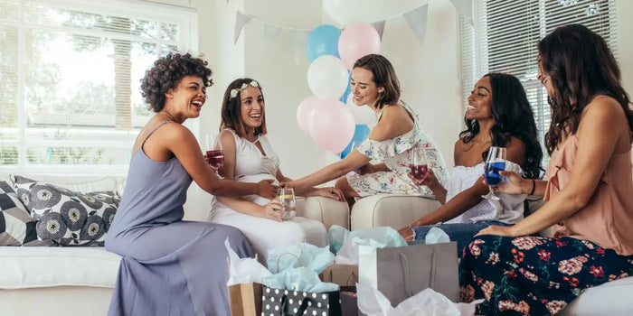 Une future maman entourée de ses amies et recevant des cadeaux pour femme enceinte.