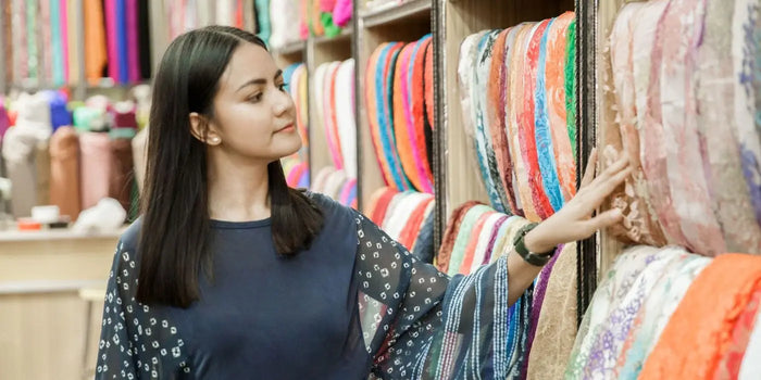 Femme choisissant des tissus pour une robe invitée mariage raffinée. 