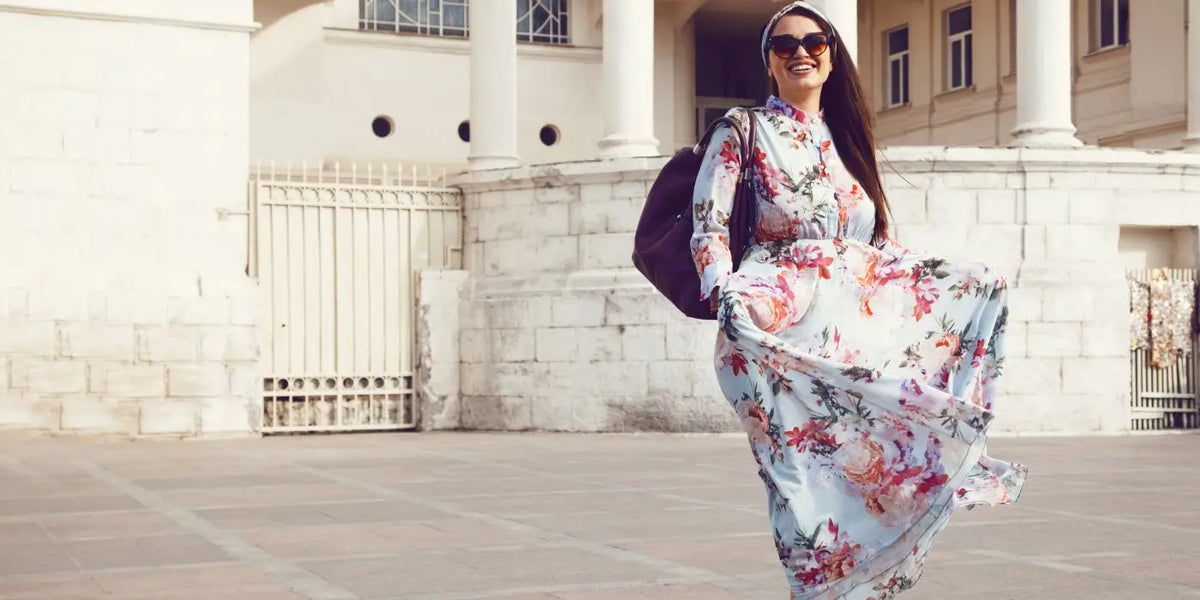 Femme qui a du ventre portant une robe fleurie. 