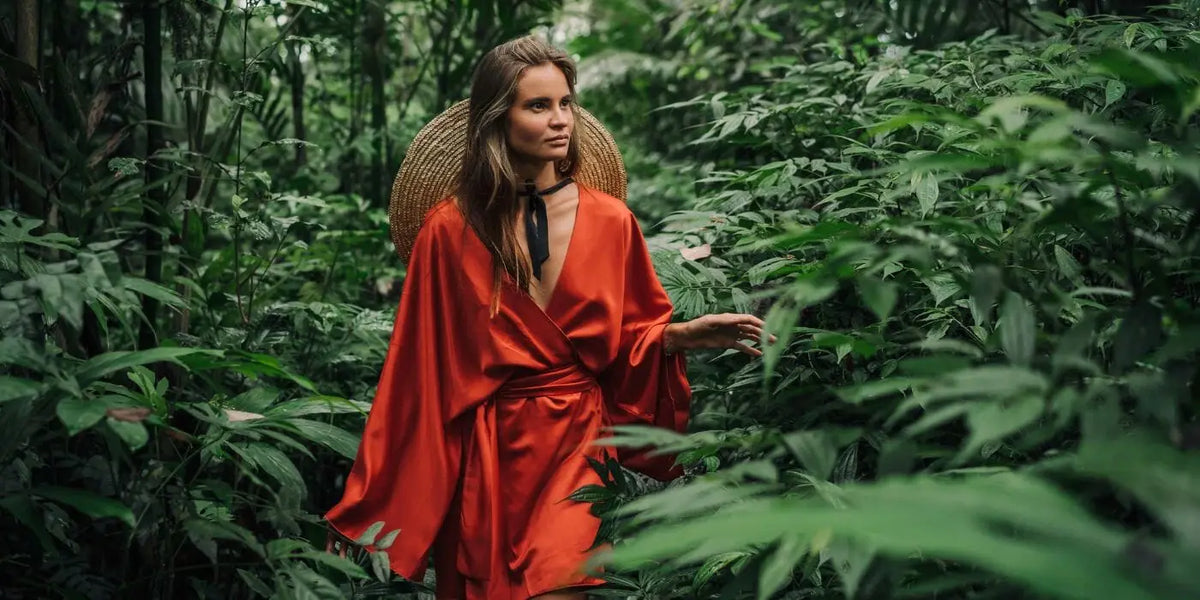 Femme portant une robe orange qui met en valeur sa peau mate.