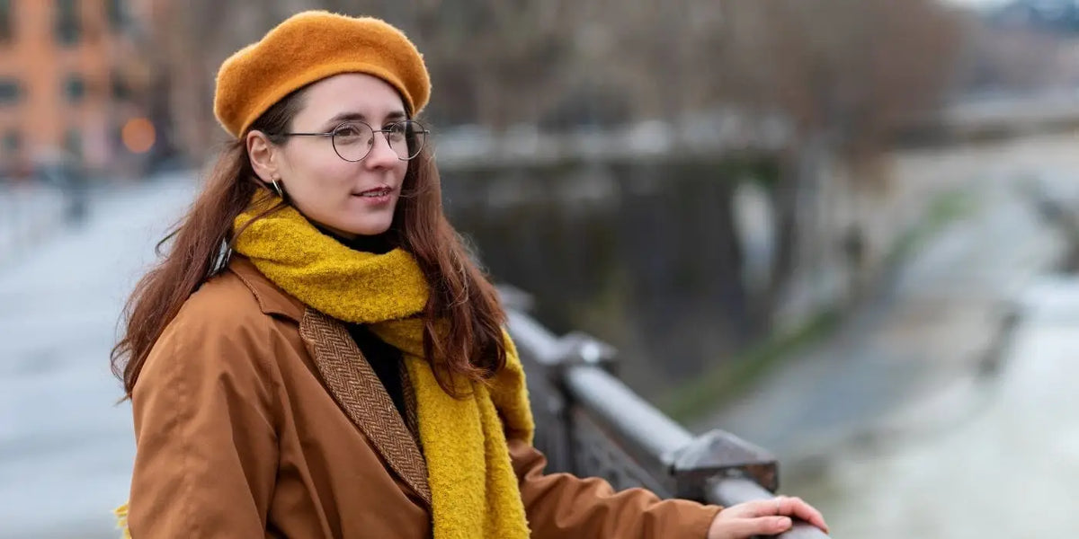 Femme portant un béret, une écharpe, une robe pull et un manteau d'hiver.