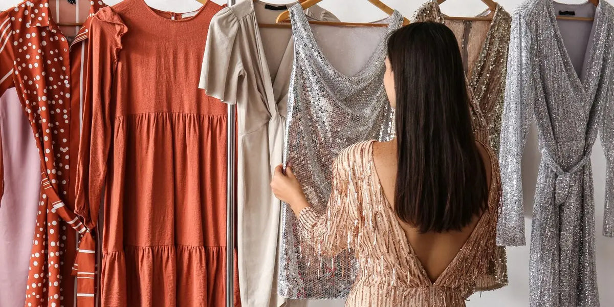 Femme choisissant une robe dos nu.