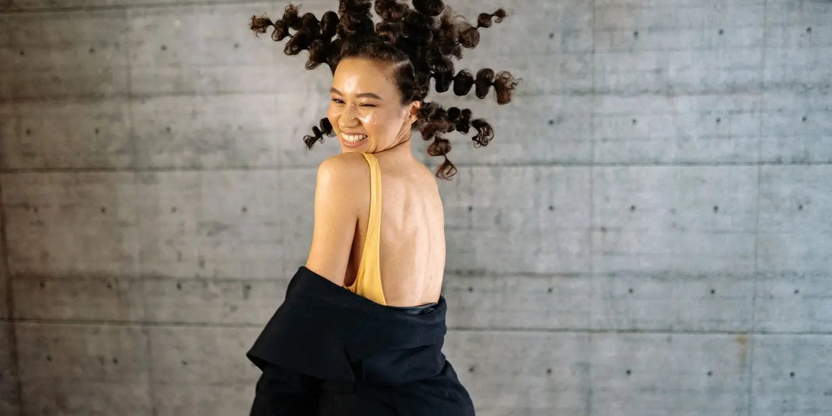 Femme portant une robe dos nu avec une veste noire.