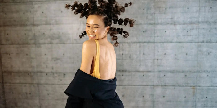 Femme portant une robe dos nu avec une veste noire.