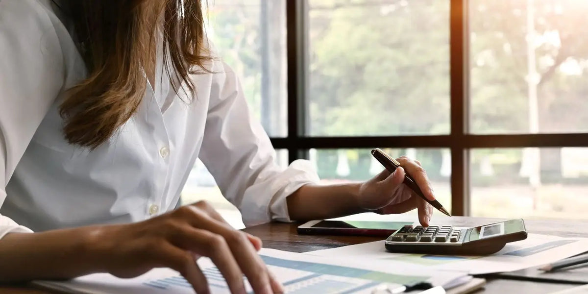 Femme calculant sa taille de soutien-gorge grâce à une calculatrice, avant de découvrir le calcul automatique en ligne de taille de soutien-gorge.