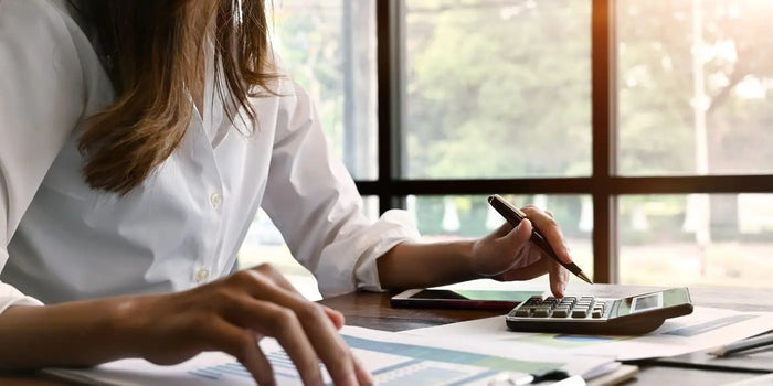 Femme calculant sa taille de soutien-gorge grâce à une calculatrice, avant de découvrir le calcul automatique en ligne de taille de soutien-gorge.