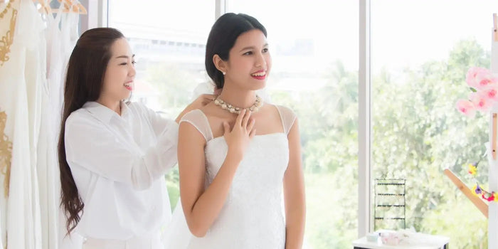 Mariée qui essaie se robe et ses bijoux.