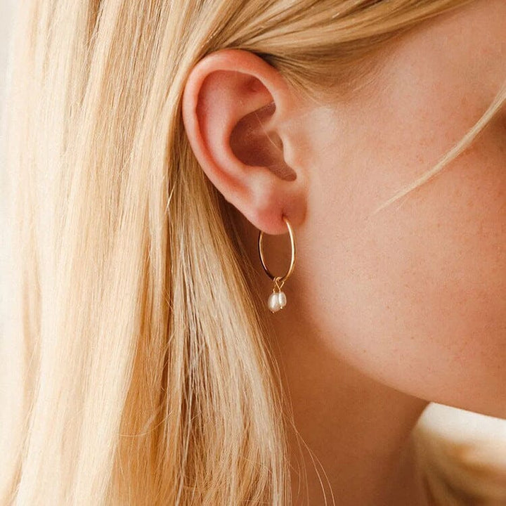 boucles d'oreilles perles pendantes lucile portées sur oreille femme blonde élégante