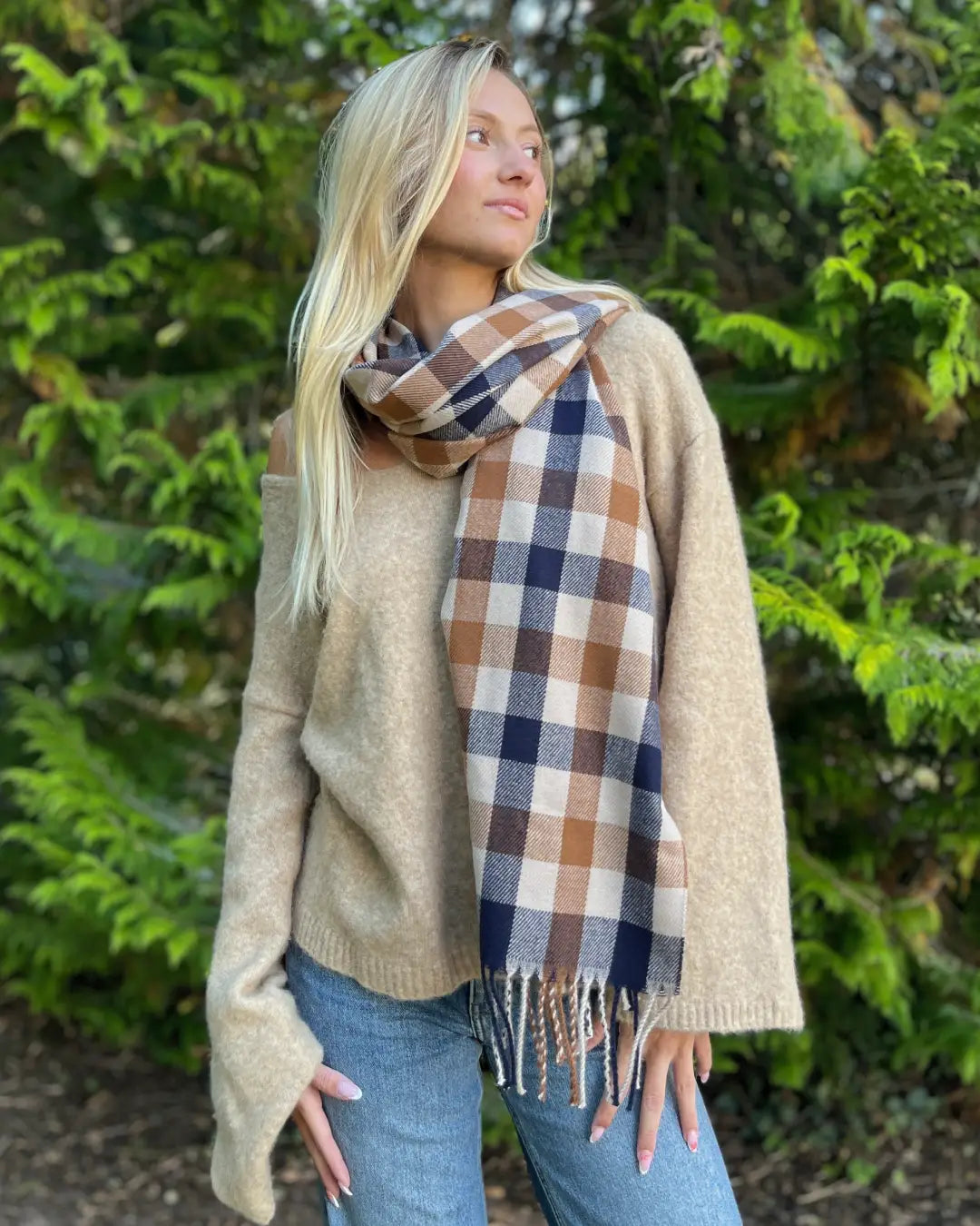 Femme portant une écharpe à carreaux en cachemire, style élégant pour l'hiver, accessoire chic et tendance pour femme.