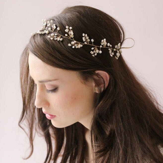 Accessoire cheveux mariage Elia en perles fines, délicatement posé sur les cheveux bruns d'une femme élégante.