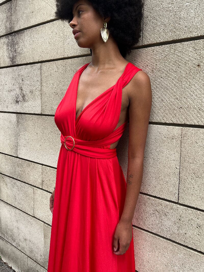 Femme portant une robe rouge avec une boucle décorative de 5 cm, accessoire polyvalent et élégant pour diverses occasions.