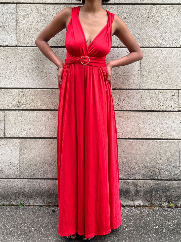 Femme portant une robe longue rouge avec boucle 5 cm, accessoire pour personnaliser une robe multipositions élégante.
