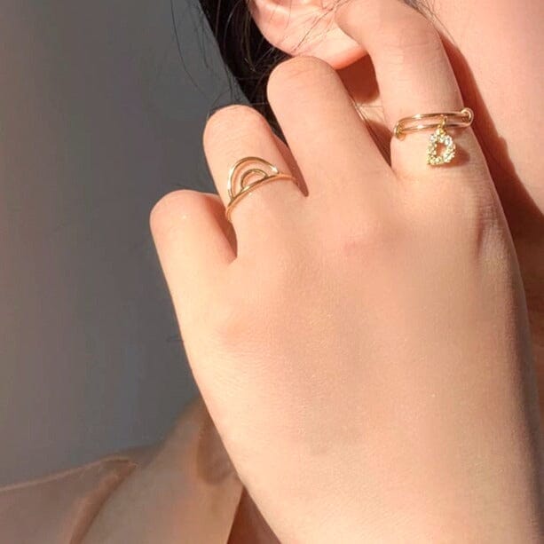 Bague dorée demi cercle sur main, élégante avec lumière douce, bijou pour femme, accessoire tendance, style minimaliste.