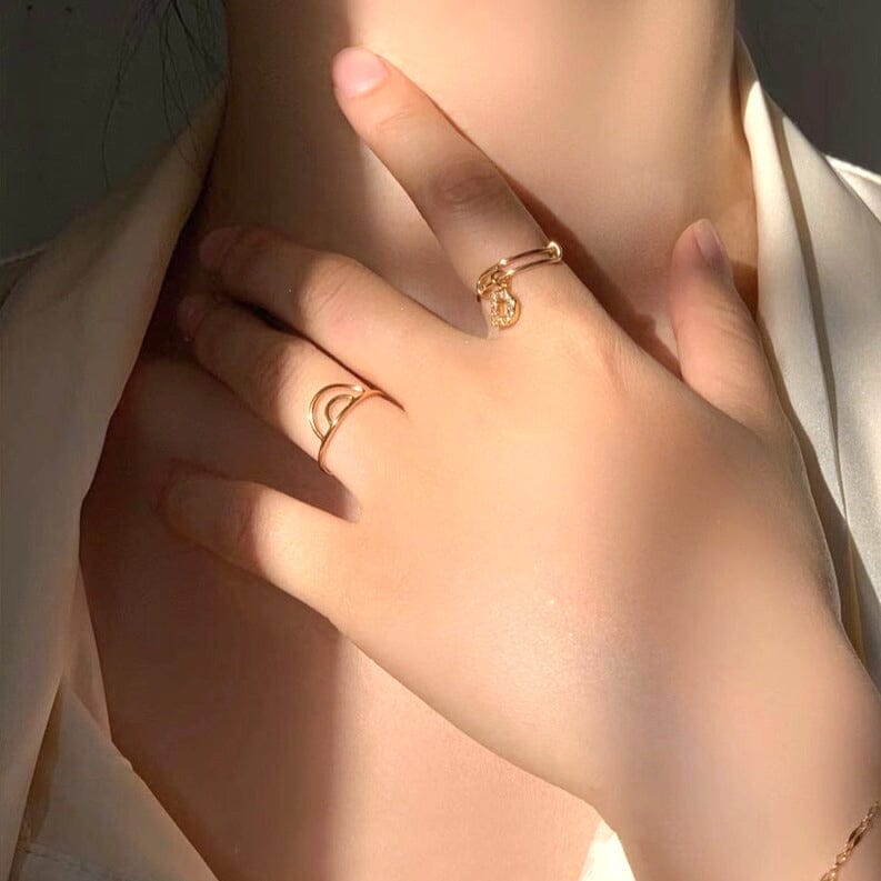 Bague demi cercle en or portée sur un doigt féminin, parfaite pour un look élégant et moderne. Bijou doré tendance.