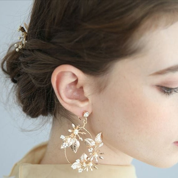 bijoux de cheveux mariage marina montrant un accessoire doré élégant pour cheveux et grandes boucles d’oreilles florales