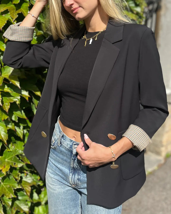 Veste blazer noire élégante pour femme avec manches retroussées, parfaite pour un look chic et décontracté.