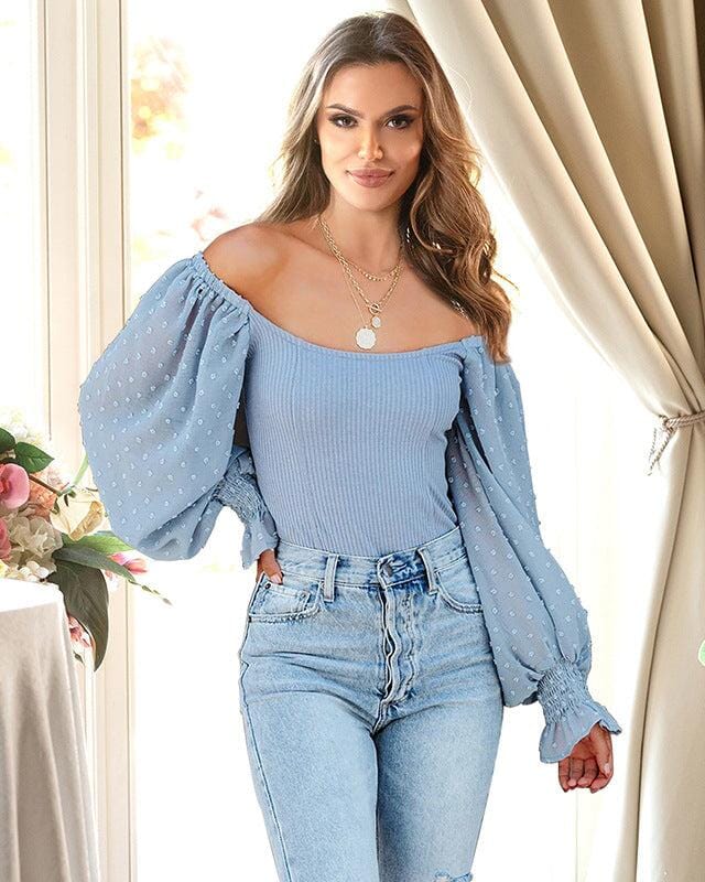 Femme portant un body manches bouffantes Lucienne bleu, style décontracté et chic idéal pour sorties ou événements.