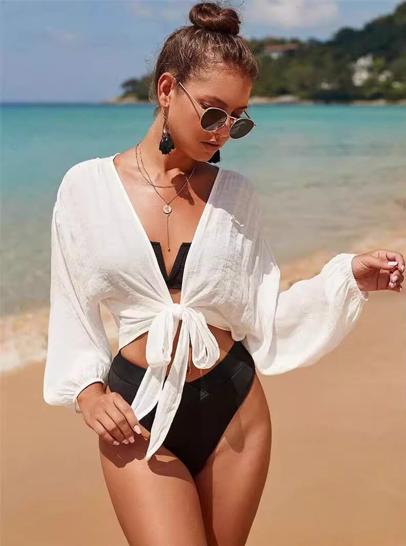 chemise de plage délila en lin blanc pour femme, idéale pour l'été, portée par un mannequin à la plage, mode estivale 2023
