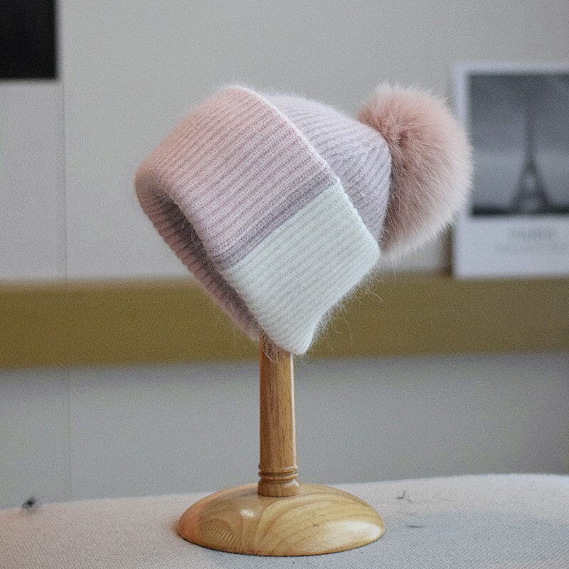 Bonnet à pompon rose et gris, modèle Coline en laine et acrylique, idéal pour l'hiver, sur support en bois.