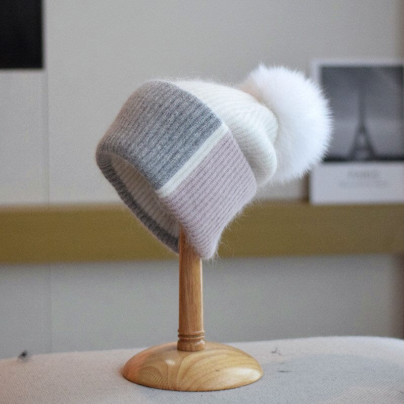 bonnet à pompon coline en laine grise, blanche et rose sur un support en bois, accessoire d'hiver élégant et moderne