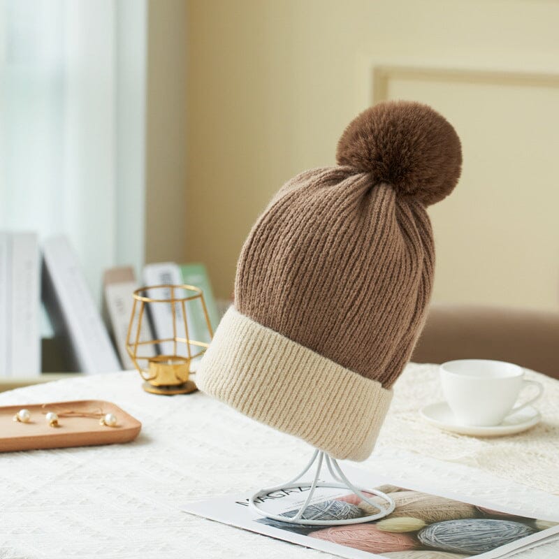 bonnet polaire en laine beige et marron pauline, idéal pour les journées froides, sur une table avec une tasse et des livres