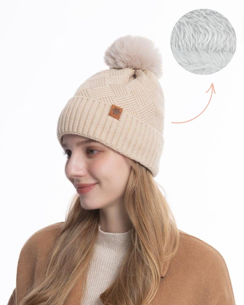 Femme portant le bonnet Giada beige avec pompon, look automne-hiver élégant et moderne, nouveauté 2023 fashion.