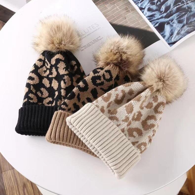 Bonnet à pompon fourrure Kira tendance léopard en laine douce, idéal pour l'hiver et pour un style cozy chic.