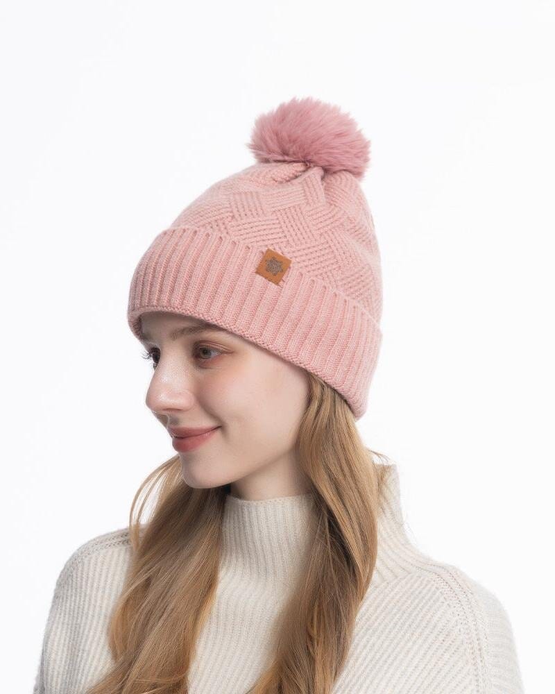 Bonnet en laine rose avec pompon, idéal pour l'hiver, présenté par modèle souriant avec cheveux longs blonds.