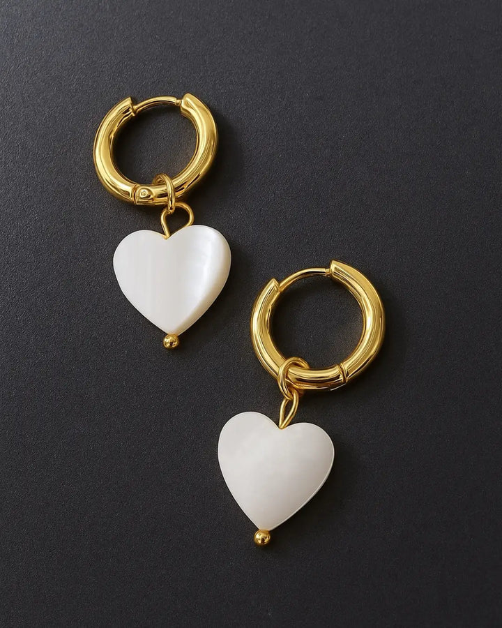 Boucles d'oreilles dorées avec pendentifs en forme de cœur nacré, design élégant et raffiné pour la collection Irma.