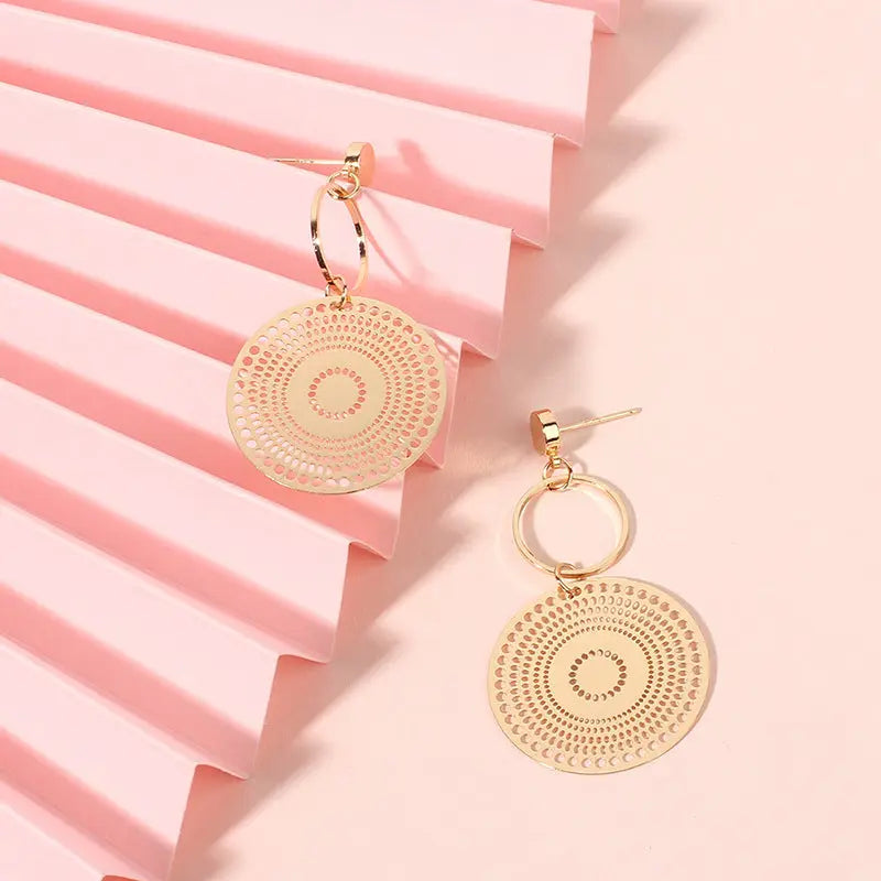 boucles d'oreilles élégantes en métal doré avec motifs circulaires ethniques sur fond rose, collection chic actuel
