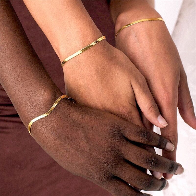 bracelet maille miroir Éma doré porté sur les poignets de deux personnes